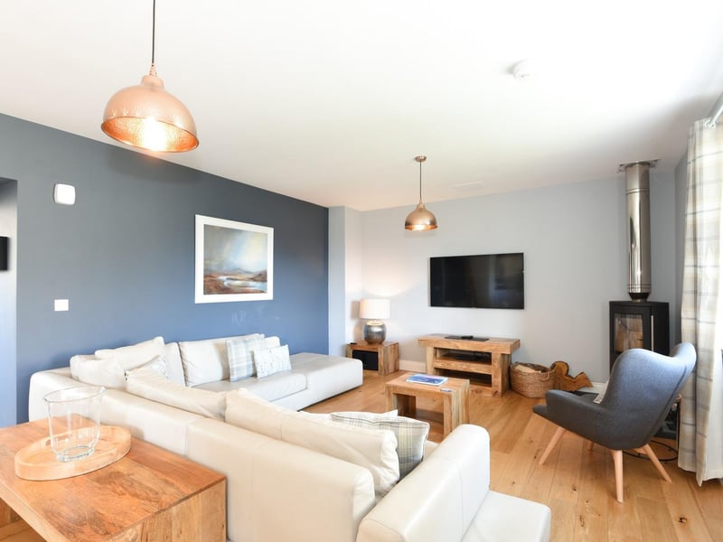 Interior: The home’s bright open-plan kitchen, dining and living space boasts a wood-burning stove and a large island. A hall leads to a secluded double bedroom, while two more are found on the first floor.