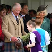 King Charles, Queen Camilla and Princess Anne are given flowers as they attend the annual Braemar Gathering on Saturday (Picture: Andy Buchanan/AFP via Getty Images)