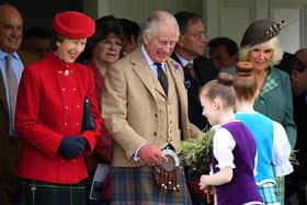 King Charles, Queen Camilla and Princess Anne are given flowers as they attend the annual Braemar Gathering on Saturday (Picture: Andy Buchanan/AFP via Getty Images)