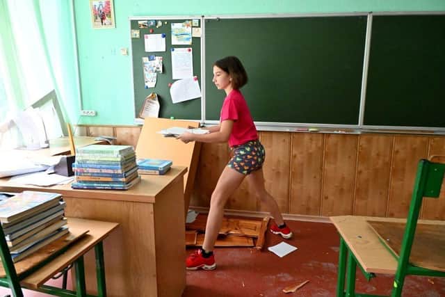 A girl retrieves books from the M.V. Lomonosov gymnasium after it was destroyed by a Russian missile strike, in the centre of the Ukrainian city of Kharkiv, on July 10, 2022. Picture: SERGEY BOBOK/AFP via Getty Images