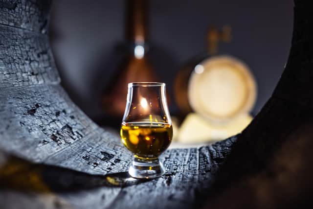 A glass of whisky in old oak barrel