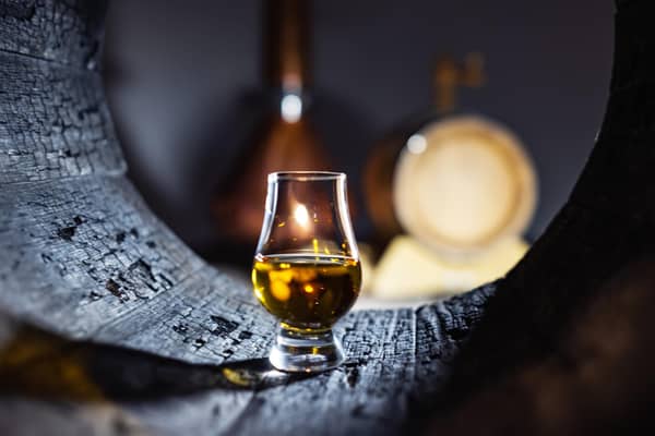 A glass of whisky in old oak barrel