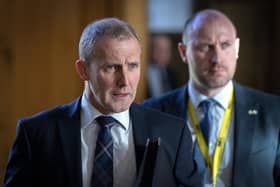 Former health secretary Michael Matheson leaves the main chamber after First Minster's Questions at the Scottish Parliament. He is pictured alongside his replacement in the health portfolio, Neil Gray. Picture: Jane Barlow/PA Wire