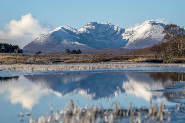 The snow-covered peak of Beinn Eighe and the mountains of Torridon are reflected in Loch Droma near Ullapool, Wester Ross. Jane Barlow/PA Wire