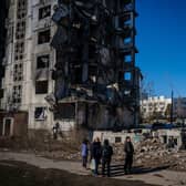 Ukrainian bystanders look on to residential buildings that were destroyed during an attack, in Borodyanka on Wednesday.