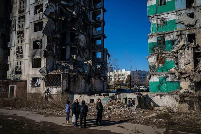 Ukrainian bystanders look on to residential buildings that were destroyed during an attack, in Borodyanka on Wednesday.