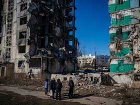 Ukrainian bystanders look on to residential buildings that were destroyed during an attack, in Borodyanka on Wednesday.