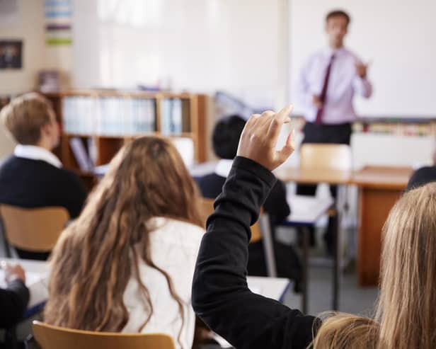 Student Raising Hand To Ask Question In Classroom. Picture: Adobe Stock