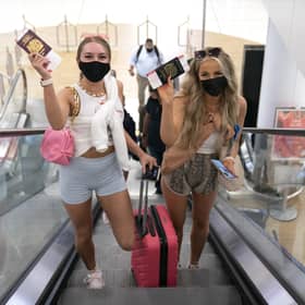 Friends Poppy (left) and Shannon, both aged 20 and from Glasgow, head towards the departure gate at Glasgow Airport after checking in for their flight to Ibiza.