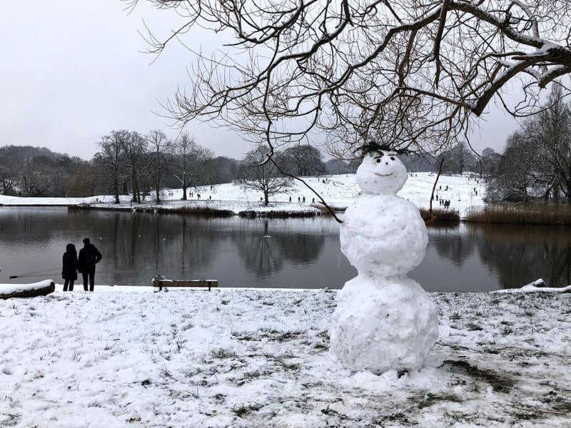 A snowman stands proud in the snow at Hampstead Heath, England.