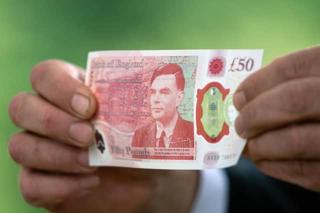 Alan Turing note enters circulation: Governor of the Bank of England Andrew Bailey poses for a photograph with the new fifty pound (GBP) note, featuring an image of mathematician and scientist Alan Turing, at Bletchley Park in Milton Keynes, on June 21, 2021. (Image credit: Joe Giddens via Getty Images)