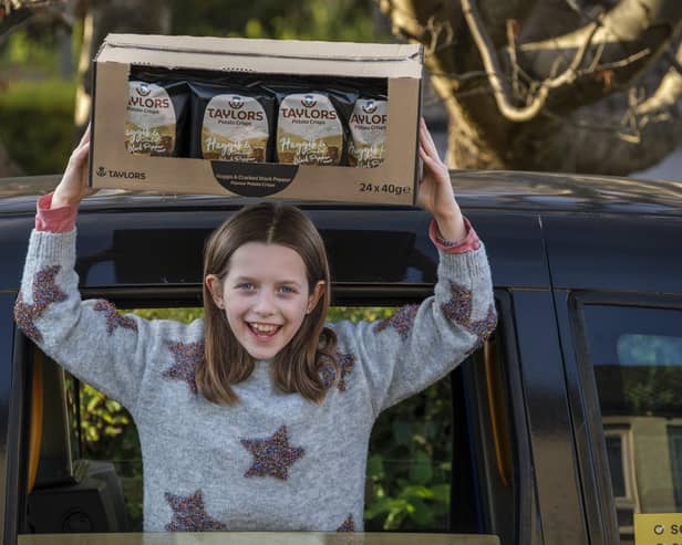 10-year-old Grace with some of her year's supply of crisps. Photo: Mike Wilkinson/Taylors Snacks/PA Wire