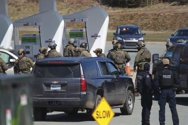 Royal Canadian Mounted Police officers prepare to take a suspect at a gas station in Enfield, Nova Scotia, Sunday April 19, 2020 (Tim Krochak/The Canadian Press via AP)