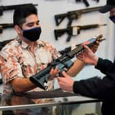 A customer considers buying a custom made AR-15-style rifle in a gun shop in the United States