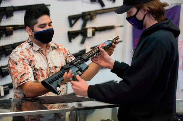 A customer considers buying a custom made AR-15-style rifle in a gun shop in the United States