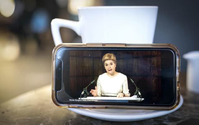 First Minister Nicola Sturgeon delivering an update statement is streamed on a smartphone during a virtual session of the Scottish Parliament