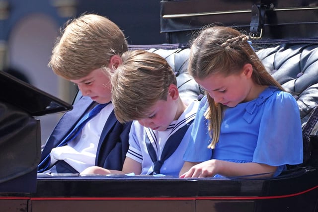 Prince George (left), Prince Louis and Princess Charlotte bow their heads as they receive a salute as the Royal Procession returns to Buckingham Palace.