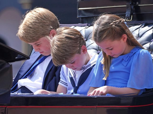Prince George (left), Prince Louis and Princess Charlotte bow their heads as they receive a salute as the Royal Procession returns to Buckingham Palace.