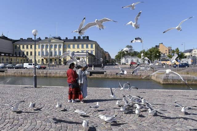 Tourists feed seagulls in front of the Presidential palace in Helsinki, Finland. The country was named the happiest nation in the world for the sixth year in a row.
