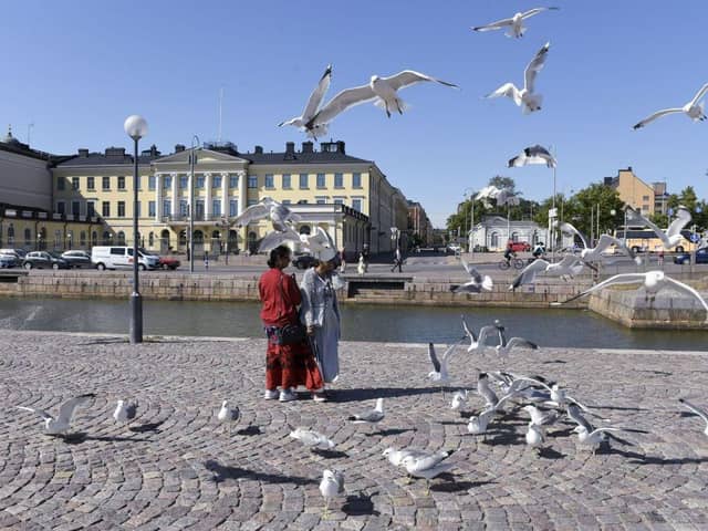 Tourists feed seagulls in front of the Presidential palace in Helsinki, Finland. The country was named the happiest nation in the world for the sixth year in a row.