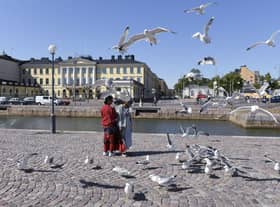 Tourists feed seagulls in front of the Presidential palace in Helsinki, Finland. The country was named the happiest nation in the world for the sixth year in a row.