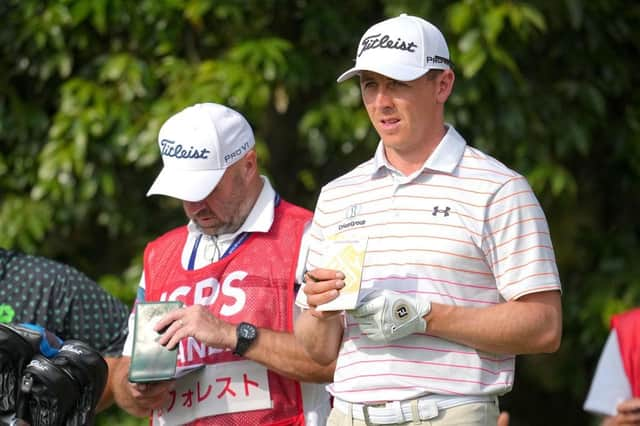 Grant Forrest checks his yardage along with caddie Dave Kenny on the sixth tee in the second round of the ISPS Handa Championship at PGM Ishioka GC in Japan. Picture: Yoshimasa Nakano/Getty Images.