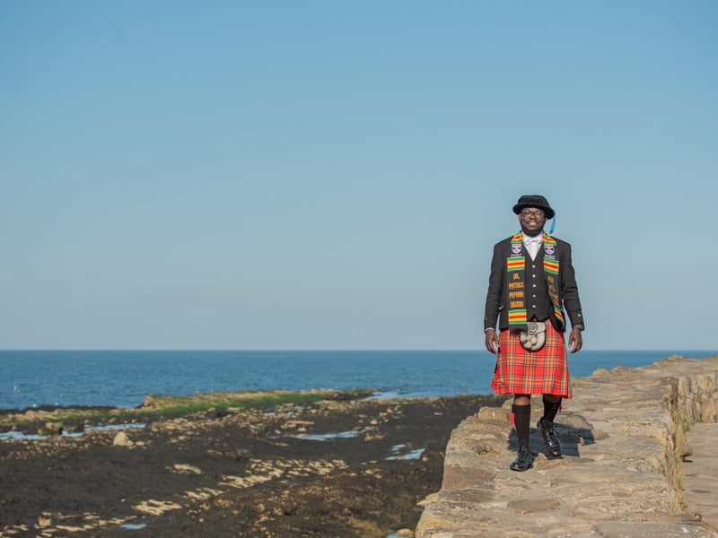 Patrick Obuobi from Ghana dressed in a kilt especially made for his graduation day at the University of St Andrews, Tuesday 13 June 2023. Patrick graduated with a PhD in International Relations and wore a scarf made in Ghana for the day.