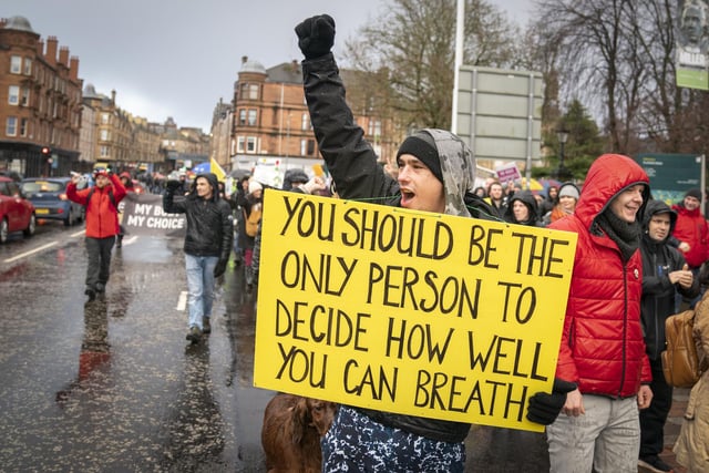 Another person taking part in the protest carrying a sign which says: "You should be the only person to decide how well you can breathe".