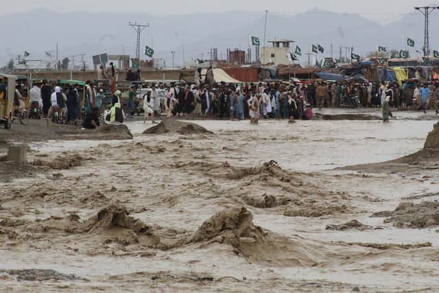 People wade through muddy floodwater in the border town of Chaman, Balochistan province, after heavy monsoon rains hit much of Pakistan (Picture: Abdul Basit/AFP via Getty Images)