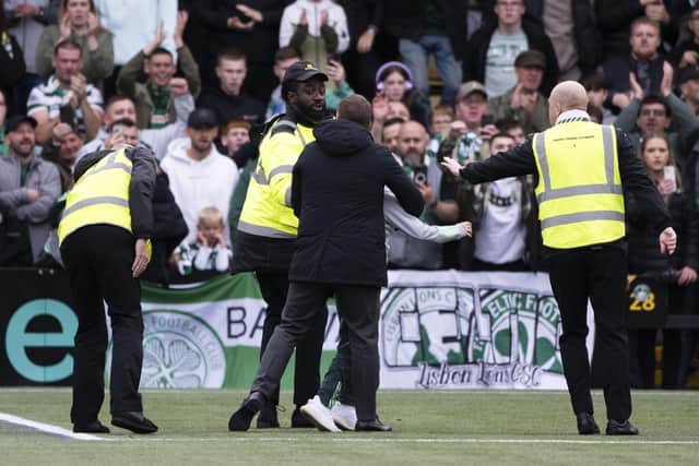 Celtic manager Brendan Rodgers intervenes as a young fan is huckled by stewards. (Photo by Paul Devlin / SNS Group)