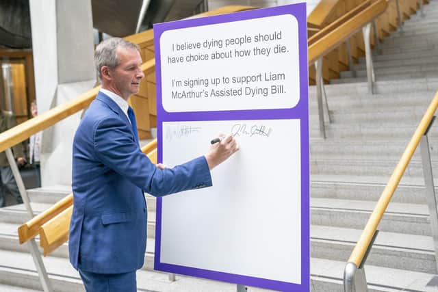Liam McArthur MSP signs a pledge card in support of his Assisted Dying Bill at the Scottish Parliament (Picture: Jane Barlow/PA)