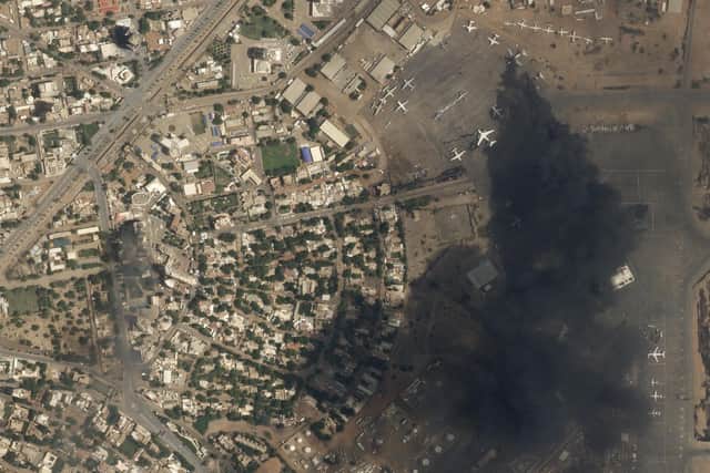 This satellite photo by Planet Labs PBC shows two burning planes at Khartoum International Airport, Sudan, Sunday April 16, 2023. The Sudanese military and a powerful paramilitary group are battling for control of the chaos-stricken nation for a second day.  The weekend’s civilian death toll rose to 97. (Planet Labs PBC via AP)