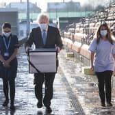 Prime Minister Boris Johnson carries Oxford AstraZeneca COVID-19 vaccine for mobile distribution during a visit to Barnet FC's ground at the Hive. Picture: Stefan Rousseau/Pool Photo via AP