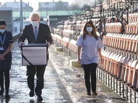 Prime Minister Boris Johnson carries Oxford AstraZeneca COVID-19 vaccine for mobile distribution during a visit to Barnet FC's ground at the Hive. Picture: Stefan Rousseau/Pool Photo via AP