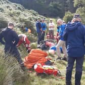 The injured cyclist being treated by mountain rescue teams before being airlifted to hospital. (Photo by Alastair Dalton/The Scotsman)