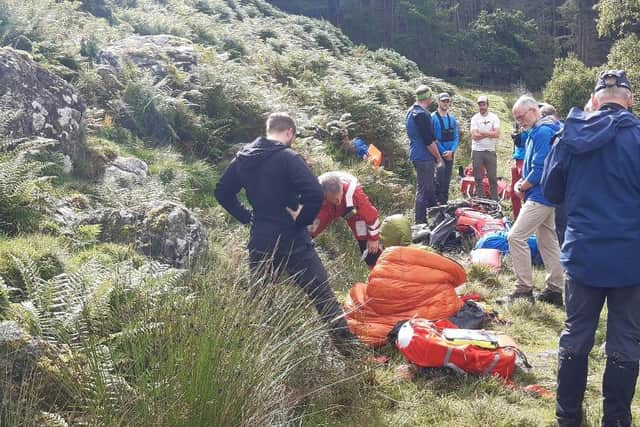 The injured cyclist being treated by mountain rescue teams before being airlifted to hospital. (Photo by Alastair Dalton/The Scotsman)