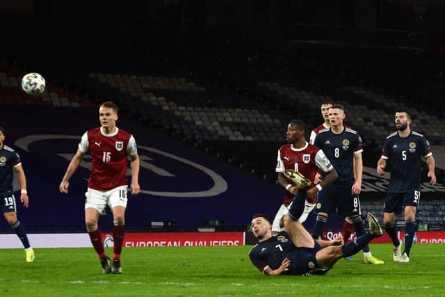 Scotland's midfielder John McGinn (C) watches as his overhead kick travels towards the goal making it 2-2 at Hampden. (Photo by ANDY BUCHANAN/AFP via Getty Images)