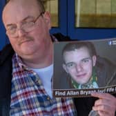 Allan Bryant Snr holds a poster for his missing son in a 2016 vigil