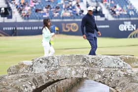 Tiger Woods walks acros the Swilcan Bridge along with his partner, Erica Herman, during a practice round prior to The 150th Open at St Andrews in July. Picture: Warren Little/Getty Images.