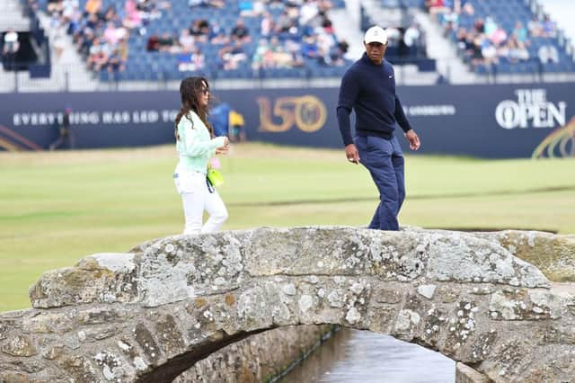 Tiger Woods walks acros the Swilcan Bridge along with his partner, Erica Herman, during a practice round prior to The 150th Open at St Andrews in July. Picture: Warren Little/Getty Images.