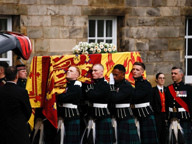 Pallbearers carrying the coffin of Queen Elizabeth II, draped with the Royal Standard of Scotland, as it arrives at Holyroodhouse, Edinburgh where it will lie in rest overnight.