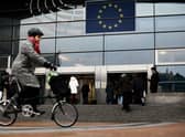 A woman rides near the entrance of the European Parliament in Brussels.