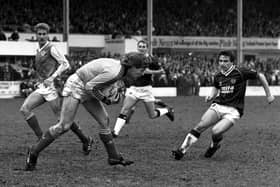 Hibs goalkeeper Andy Goram takes possession as Hearts winger John Colquhoun looks on during a goalless Edinburgh derby in March 1988