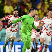 Croatia goalkeeper Dominik Livakovic is chased by his teammates after the penallty shoot-out win over Brazil in the World Cup quarter-final. (Photo by GABRIEL BOUYS/AFP via Getty Images)