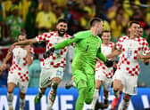 Croatia goalkeeper Dominik Livakovic is chased by his teammates after the penallty shoot-out win over Brazil in the World Cup quarter-final. (Photo by GABRIEL BOUYS/AFP via Getty Images)