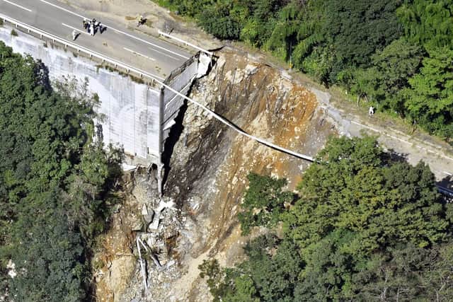 A collapsed road is seen following a typhoon in Morotsuka, Miyazaki prefecture. A tropical storm that dumped heavy rain as it cut across Japan moved into the Pacific Ocean on Tuesday after killing a few and injuring more than 100. Picture: Kyodo News via AP