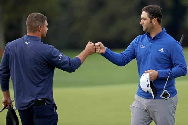 Bryson DeChambeau bumps fists with Jon Rahm after finishing on the 18th green during the continuation of the second round of the Masters at Augusta National. Picture: Patrick Smith/Getty Images