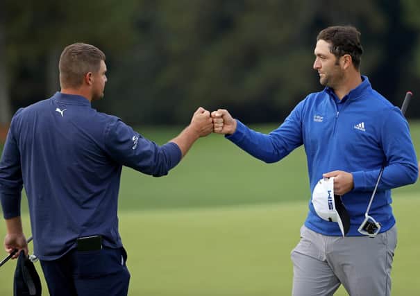 Bryson DeChambeau bumps fists with Jon Rahm after finishing on the 18th green during the continuation of the second round of the Masters at Augusta National. Picture: Patrick Smith/Getty Images