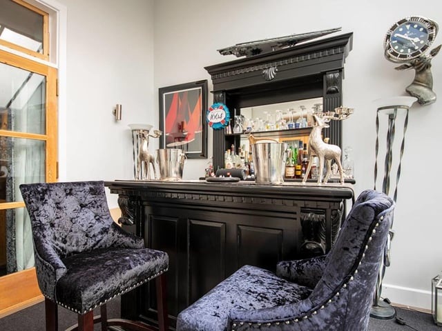 The sunroom is currently set as a bar and has skylights and a frontage of windows providing an outlook over the southerly gardens and beyond.