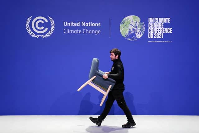 Staff remove chairs and dismantle one of the stages at COP26.